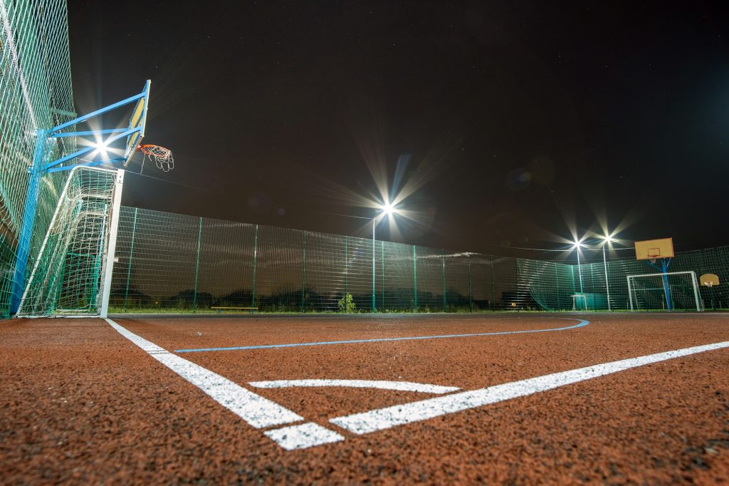 Outdoors mini football and basketball court with ball gate and basket surrounded with high